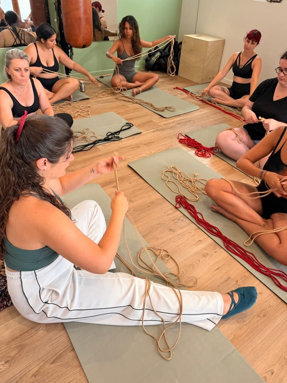 Un cercle de femmes assises sur des tapis, cordes en mains, pendant une journée de pratique
