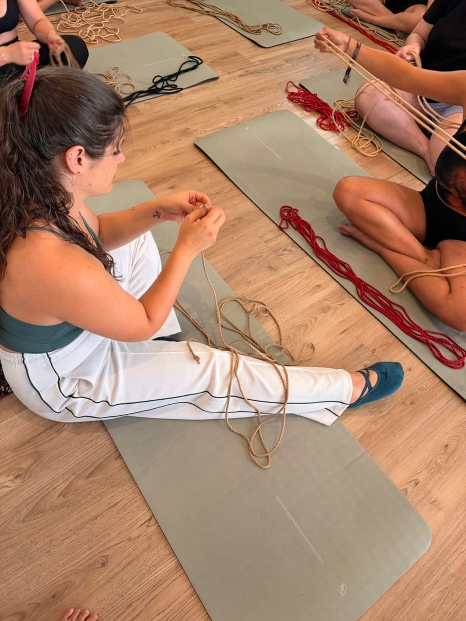 Messalina assise au sol du studio, une corde entre les mains